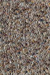 Stones of various shapes and colors are laid out on the road as a sidewalk close-up.