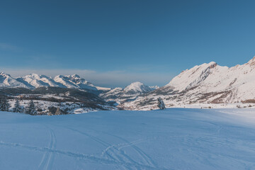 A picturesque landscape view of the French Alps mountains with ski traces in the fresh snow on a cold winter day (Hautes-Alpes, Devoluy valley)