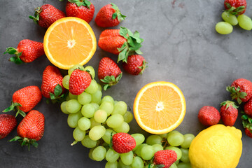 Various fruits and berries on dark gray background