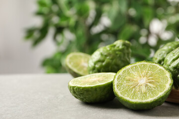 Fresh ripe bergamot fruits on light grey table against blurred background, space for text