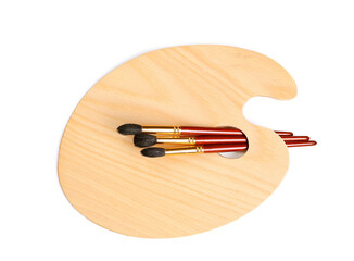 New wooden paint palette with different brushes on white background, top view