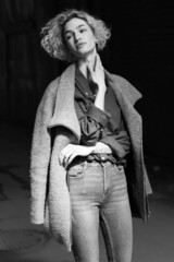 young beautiful woman posing from outside in a coat and jeans