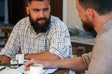 Two hipster freelance businessmen working outdoors. Horizontal image.