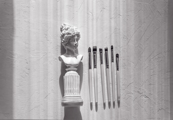 Set of professional makeup brushes on a white textured background