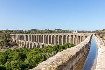Fototapeta na wymiar Tomar Aqueduct or Aqueduto de Pegoes, ancient stone masonry building, amazing monument. It was built in the 17th century to bring water to the convent of Christ in Tomar under command of king Philip I