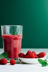 2 glasses with smoothie and drinking straws made of glass. Healthy eating and sustainability. Smoothie made from raspberries and other red fruits. Zero waste and reusable drinking straws made of glass