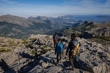 Fototapeta premium hikers descending the Puig Tomir towards Fartaritx,, Mallorca, Balearic Islands, Spain
