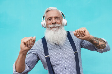 Happy hipster senior man smiling on camera while dancing to music playlist