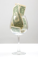 dollar banknotes money lies in an empty wine glass. business in the wine industry. alcohol marketing