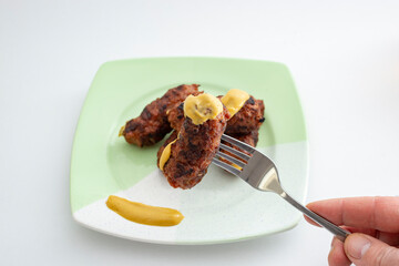 Mici or mitititei (traditional romanian food) with mustard on a ceramic plate, on white background....