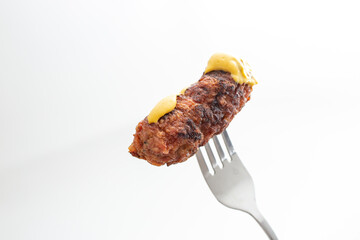 Traditional Romanian grilled minced meat, mici or mititei on a metal fork  - obrazy, fototapety, plakaty