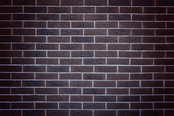 Dark brown brick wall, decorative brick tiles. Background texture of brick wall. Vignette.Copy space