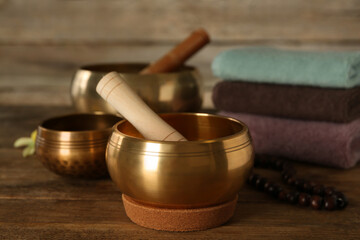 Composition with golden singing bowls on wooden table