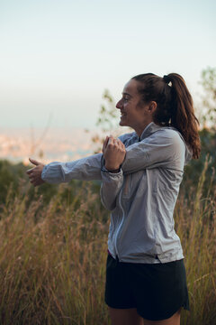 Girl doing stretching before running session outdoors