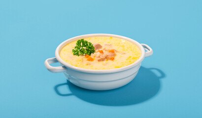 Greek soup in a white bowl, minimalist on a blue table