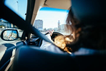 Close up of unrecognizable female with safety belt hands on the steering. Traveler girl on car...