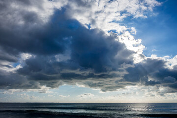 Naklejka na ściany i meble Cloudy seascape view from a beach at sunset