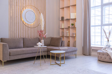 luxurious modern interior of the living room of an expensive spacious bright apartment. upholstered furniture and decorative lighting, soft pastel colors and cozy atmosphere