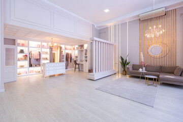 spacious expensive luxury bright interior of open-plan apartment in pink colors with dressing room, bedroom area and cozy area for guests with soft furniture. fashionable LED lighting and huge windows