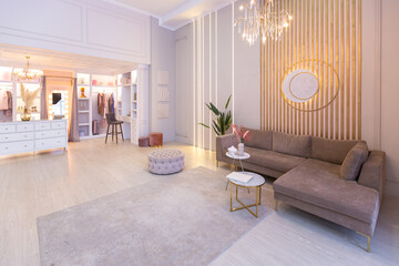 spacious expensive luxury bright interior of open-plan apartment in pink colors with dressing room, bedroom area and cozy area for guests with soft furniture. fashionable LED lighting and huge windows