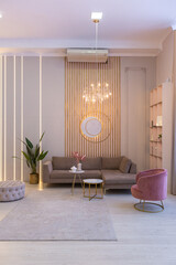 luxurious modern interior of the living room of an expensive spacious bright apartment. upholstered furniture and decorative lighting, soft pastel colors and cozy atmosphere
