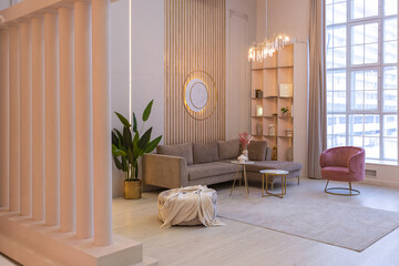 luxurious modern interior of the living room of an expensive spacious bright apartment. upholstered furniture and decorative lighting, soft pastel colors and cozy atmosphere