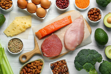Different fresh products on white wooden table, flat lay. Sources of essential amino acids