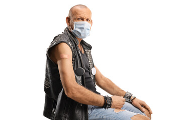 Bald man with a leather vest sitting a vaccine patch on his arm