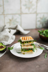 Sandwich with cottage cheese, pea hummus, avocado and young greens of spinach and beets. Nutritious healthy toast for lunch. Photo in light colors.
