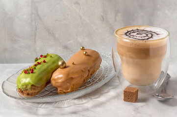 Still life with cup of latte and eclairs