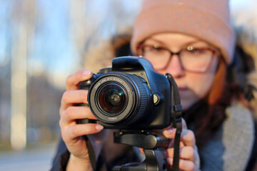 The girl shoots with a camera, a photo with a SLR camera, the girl shoots a video