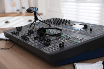 Professional audio equipment on wooden table in modern radio studio