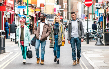 Multicultural students walking on Brick Lane center at Shoreditch London - Life style concept with multi-ethnic young friends on seasonal clothes having fun together outside - Bright vivid filter - 482690683
