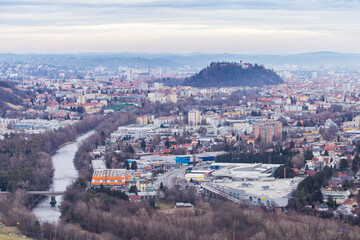 Aerial view of Graz in Austria with the mighty Schloßberg hill in the city centre on a foggy winter day