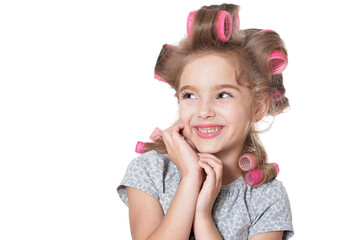 Obraz na płótnie Canvas Portrait of emotional little pretty girl with hair curlers posing isolated