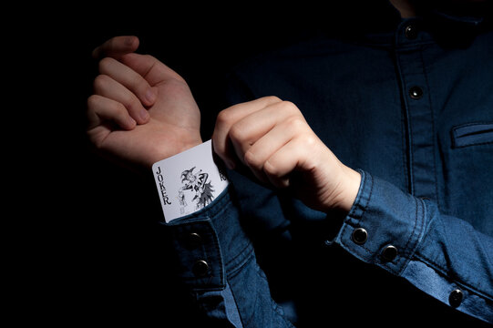 Lviv, Ukraine - 01.03.2022: human hands pulling a joker card from the sleeve