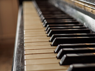 Close side view of shiny black and white old piano keys.