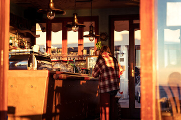 Fototapeta na wymiar Young girl in a cafe, sunset warm colors, buying drinks, autumn fall cozy vibes, Piran, Pirano, Istria, Slovenia, Slovenija