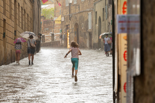 people, walking, street, rain, lifestyle, historic,  medieval, town, italian, tuscany, raining, outside,  child, running, playing, water