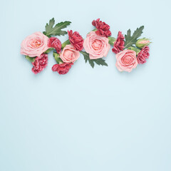 Colorful spring flowers against the pastel blue background. Spring blossom minimal flat lay.