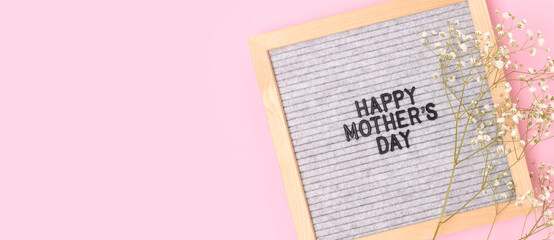 Naklejka premium Happy Mothers day. Banner with letter board and gypsophila flower on a pink background. Festive concept.