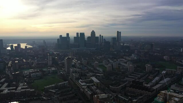 Aerial drone video of iconic skyscraper banking and business complex of Canary Wharf at sunrise, Docklands, London, United Kingdom