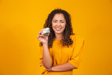 young woman with a slice of cheese in her hand. woman eating gorgonzola cheese.