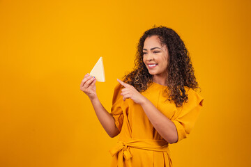 Young afro man with a slice of brie cheese in his hands pointing at him