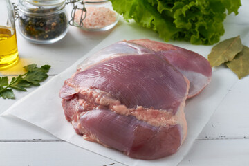 raw fresh fillet boneless turkey thigh parsley olive oil dry bay leaves peppercorns lettuce white background