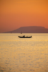 Fisherman at the lake Balaton with Szent György-hill at the background at sunset