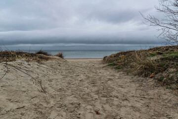 Rain clouds over the sandy beach of the Baltic Sea. Winter seascape