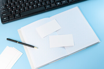 A notebook with empty white card and black keyboard. Work at home. Work in internet. Online education. Work with computer. Simple composition.