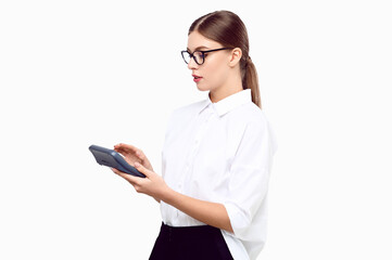 Young woman accountant with a calculator in her hands wearing white shirt glasses on a white isolated background. Business woman counting income