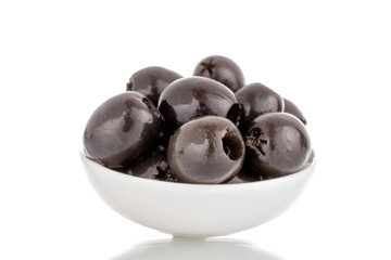 A few pickled black olives in a white saucer, macro, isolated on white.